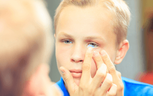 child putting in contact lens